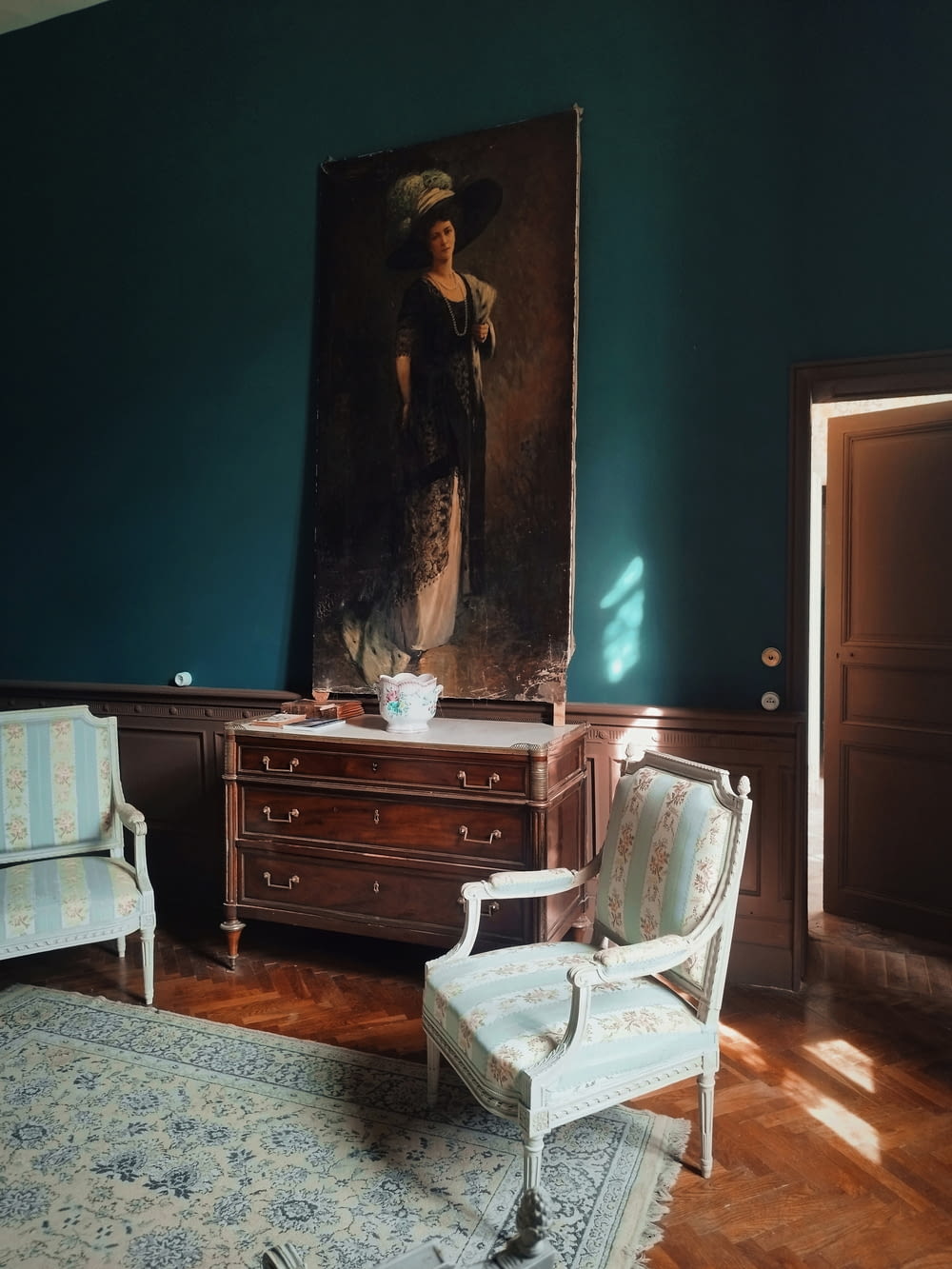 a room with a chair and a painting on the wall