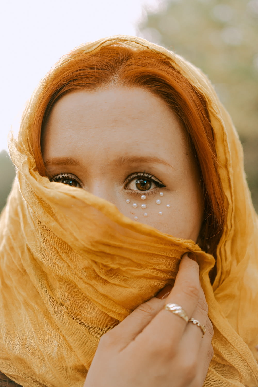 a woman wearing a yellow scarf covering her face
