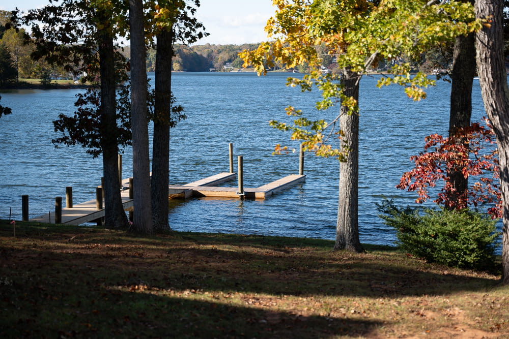 a dock in the middle of a lake surrounded by trees