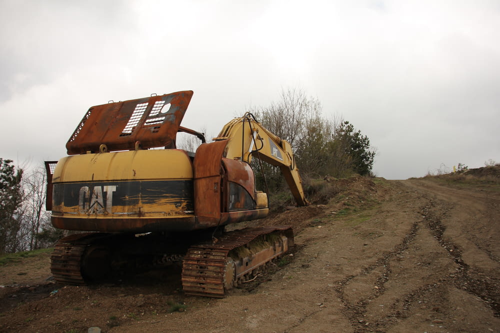 a yellow bulldozer sitting on top of a dirt road