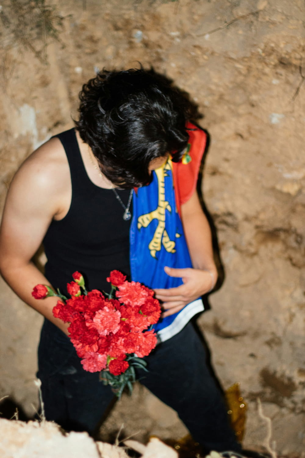 a man holding a bouquet of red flowers