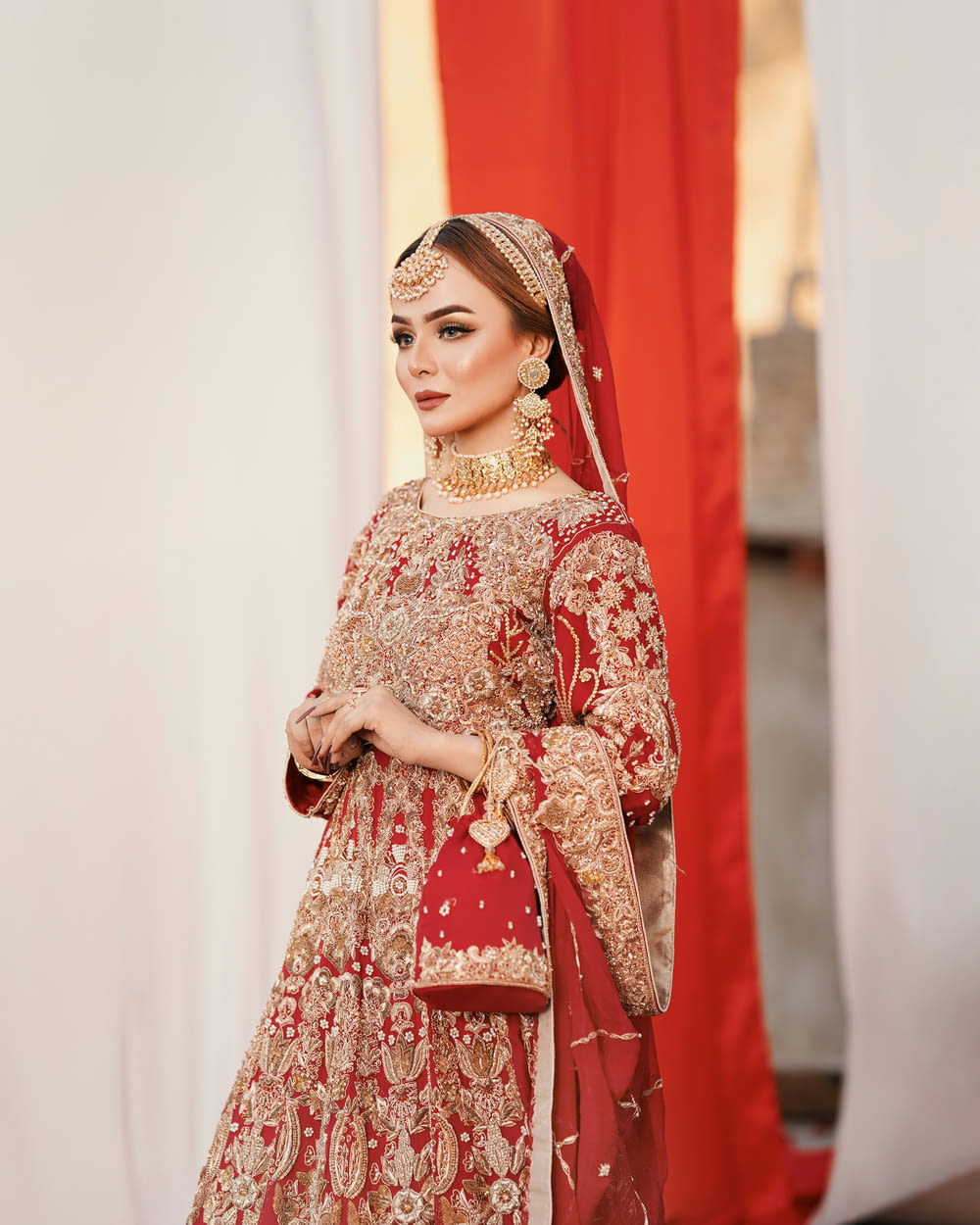 uma mulher em um vestido de noiva vermelho e dourado