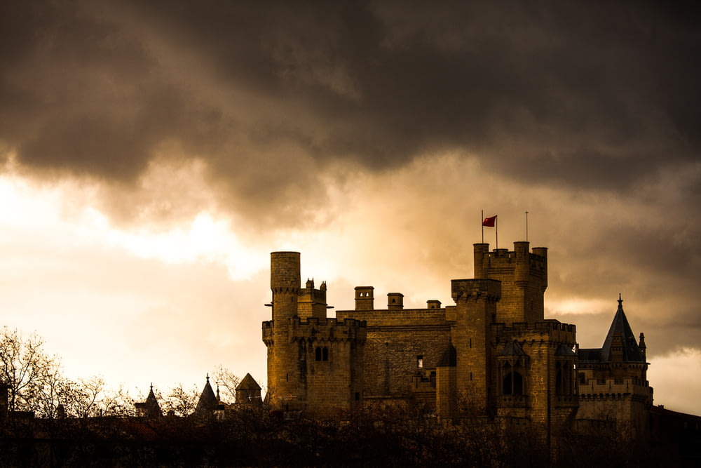 a castle with dark clouds in the background