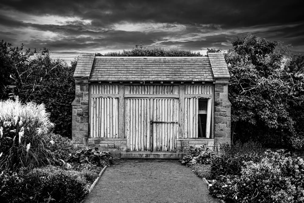 a black and white photo of a garden shed