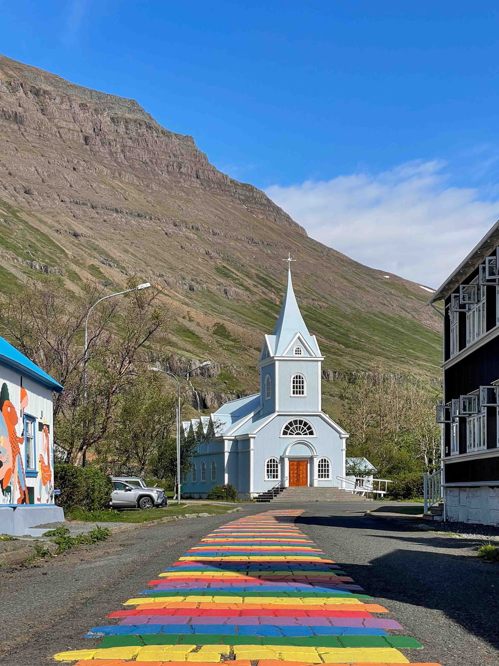 a church with a rainbow painted walkway leading to it