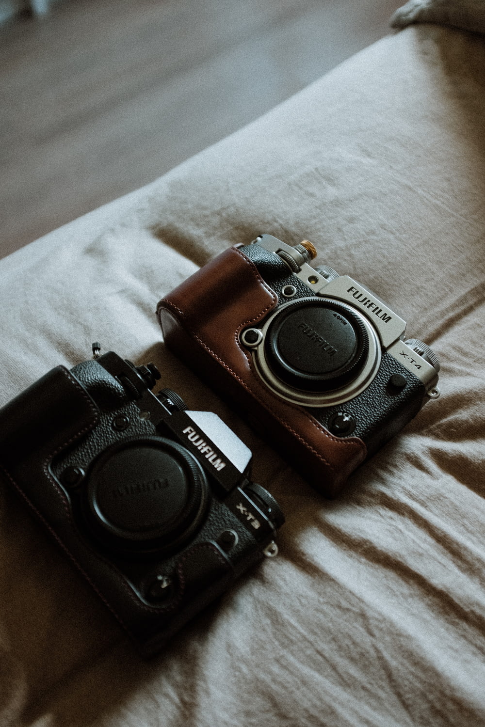a couple of cameras sitting on top of a bed