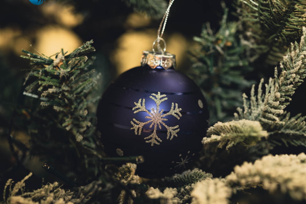 a blue ornament hanging from a christmas tree
