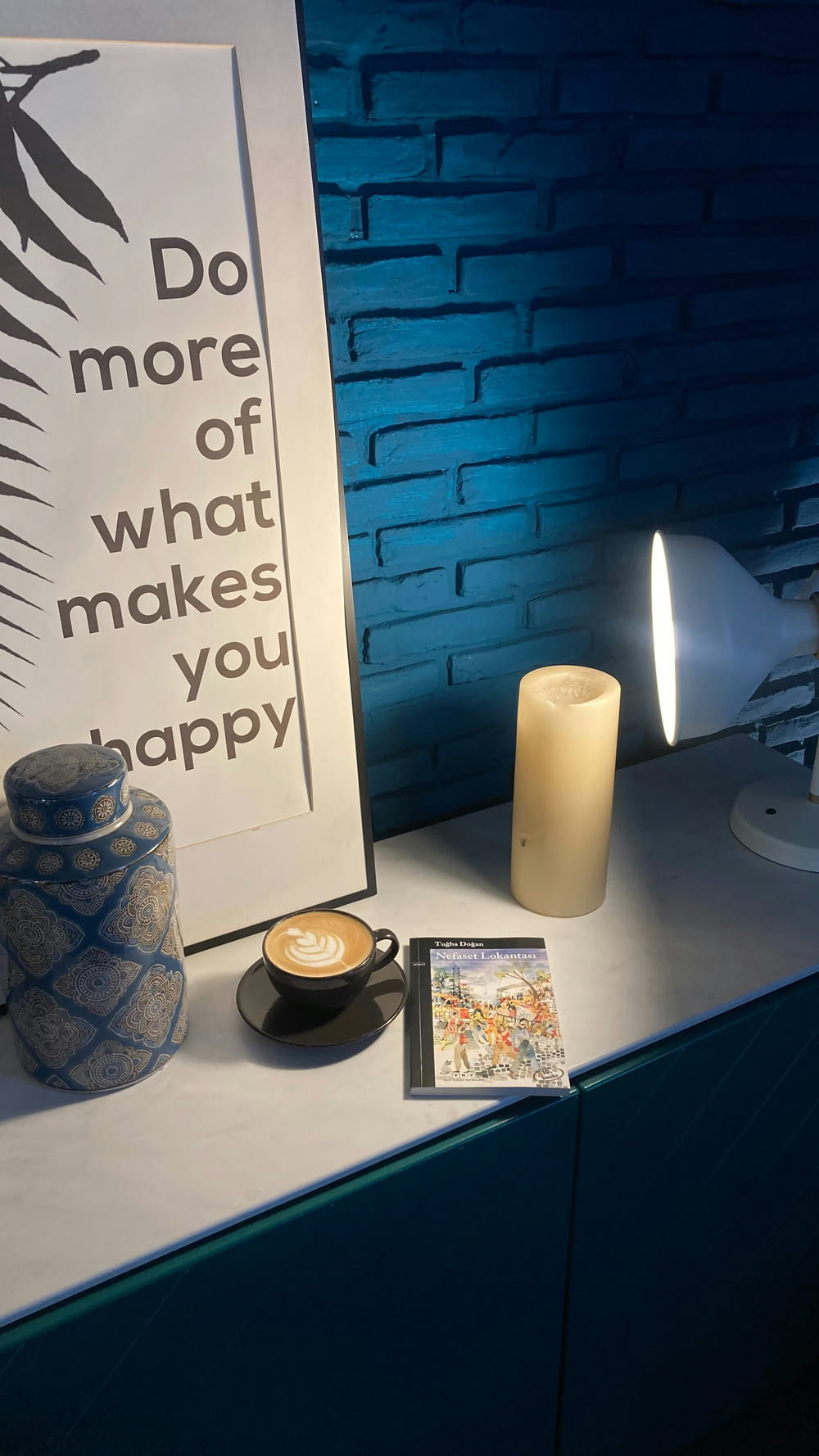 a blue brick wall with a picture and a candle