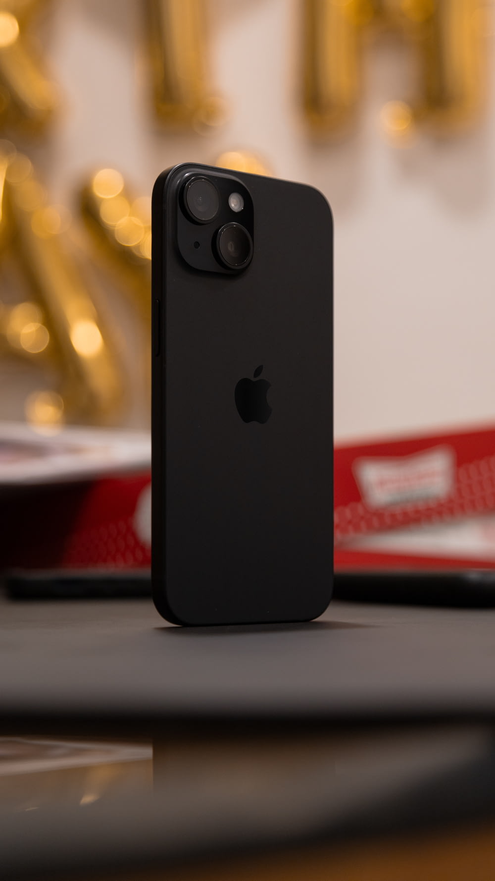 a black iphone sitting on top of a table