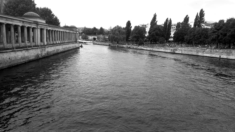 a black and white photo of a river running through a city