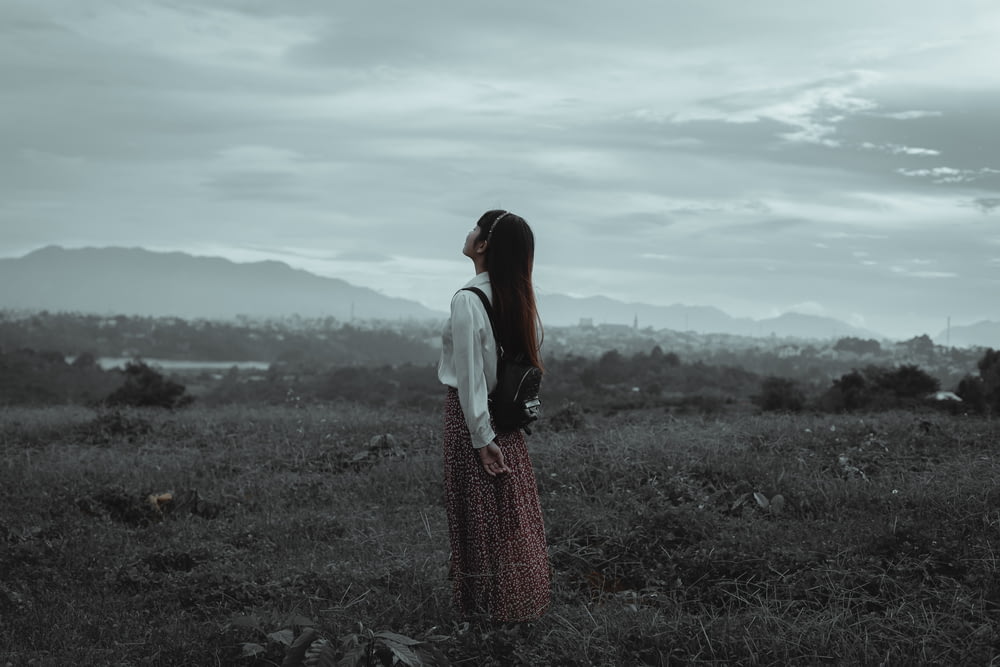 una donna in piedi in un campo che guarda il cielo