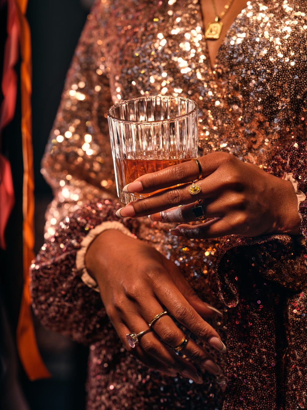 a close up of a person holding a glass of alcohol