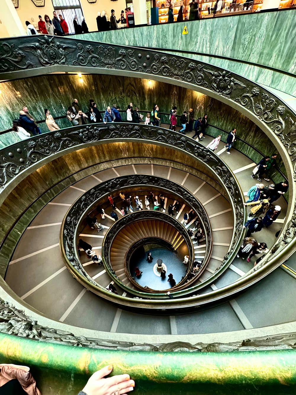 a group of people standing on top of a spiral staircase