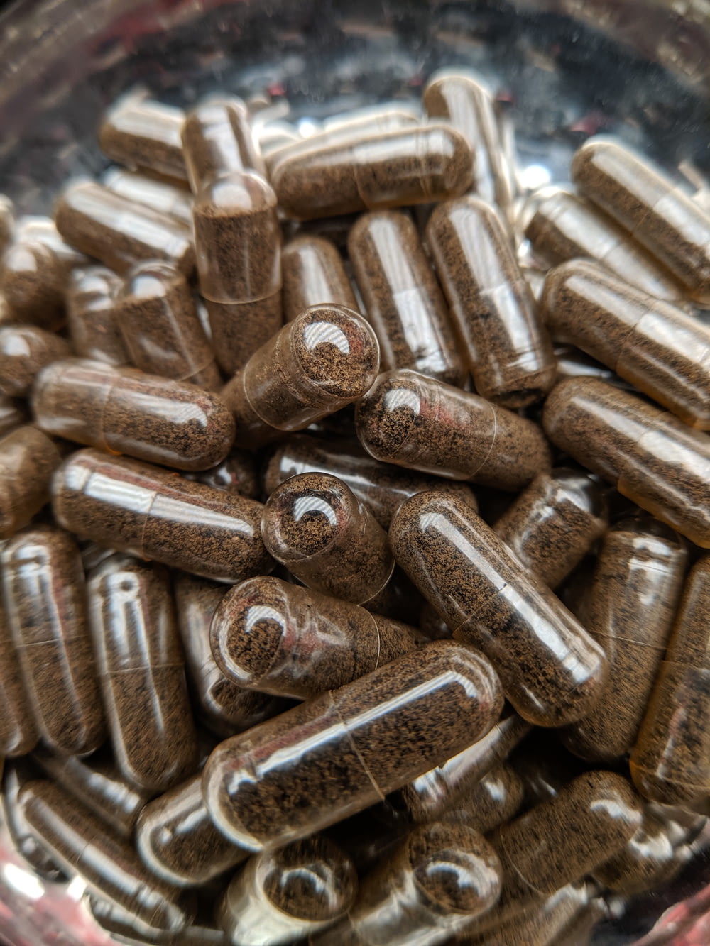 a bunch of brown pills in a glass bowl