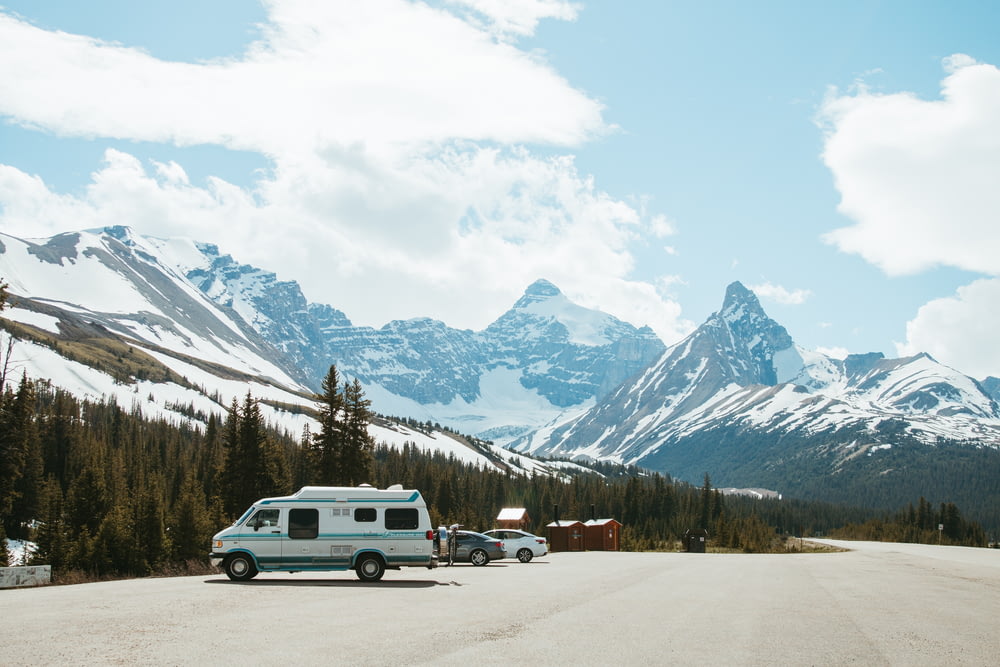 a camper parked on the side of a road with mountains in the background