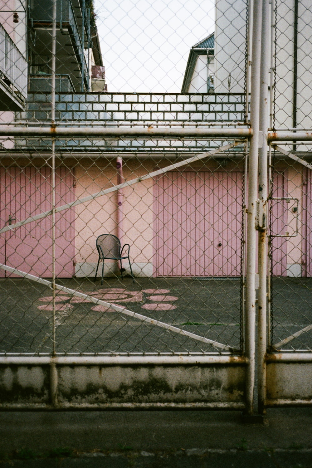 a chair sitting in front of a pink building