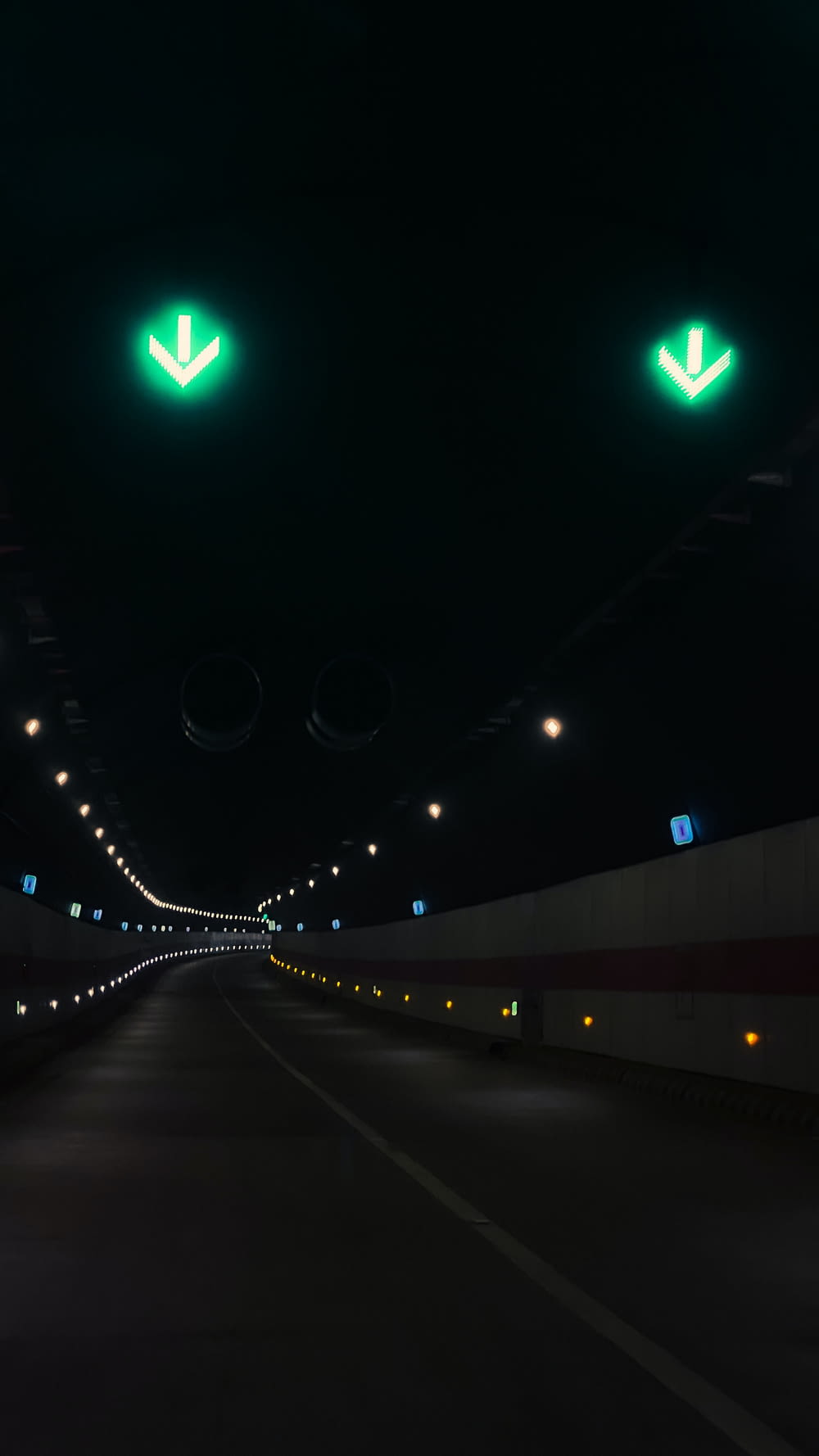 両側に緑色のライトが灯る長いトンネル