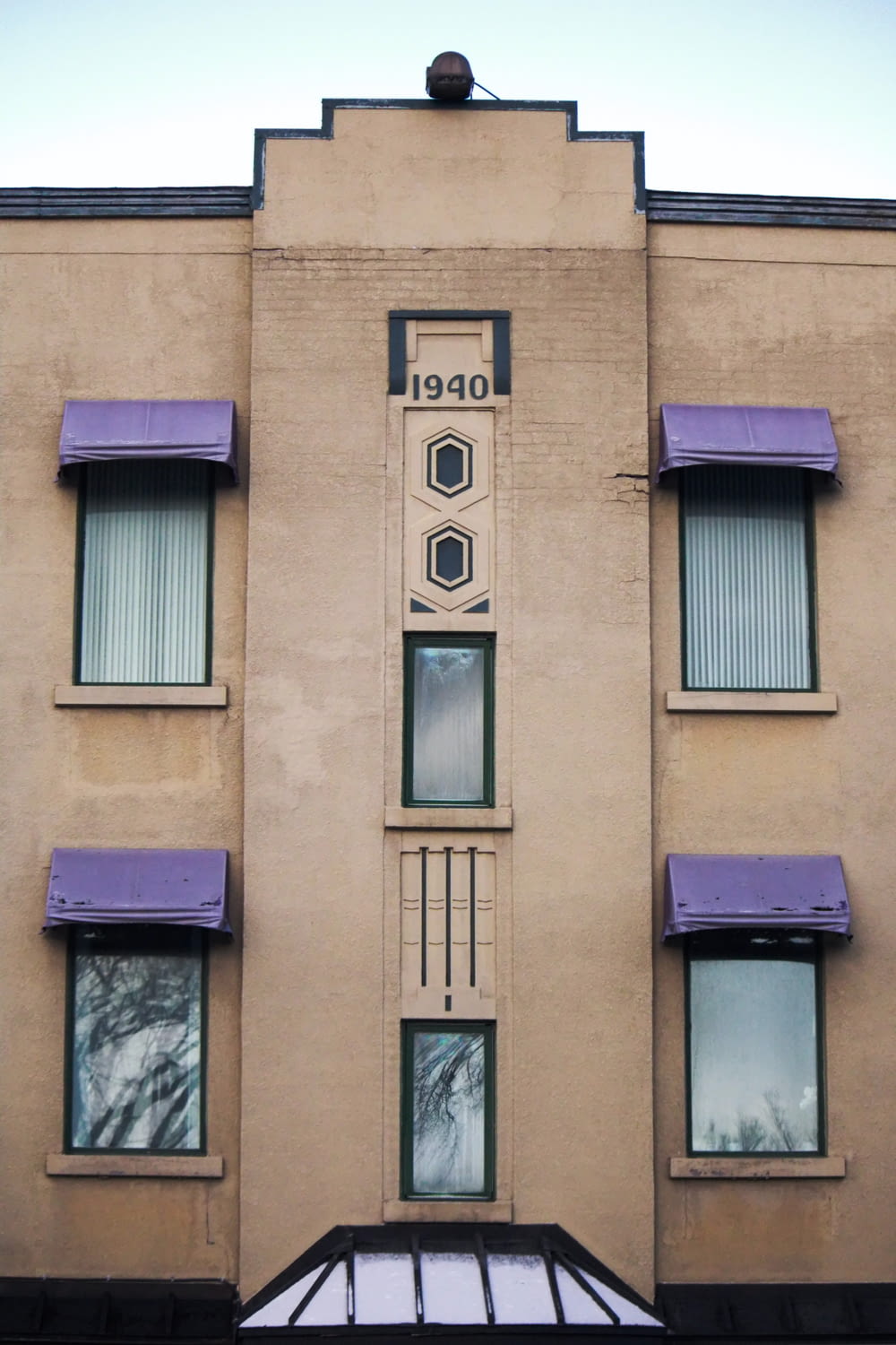 a tall building with purple awnings and windows