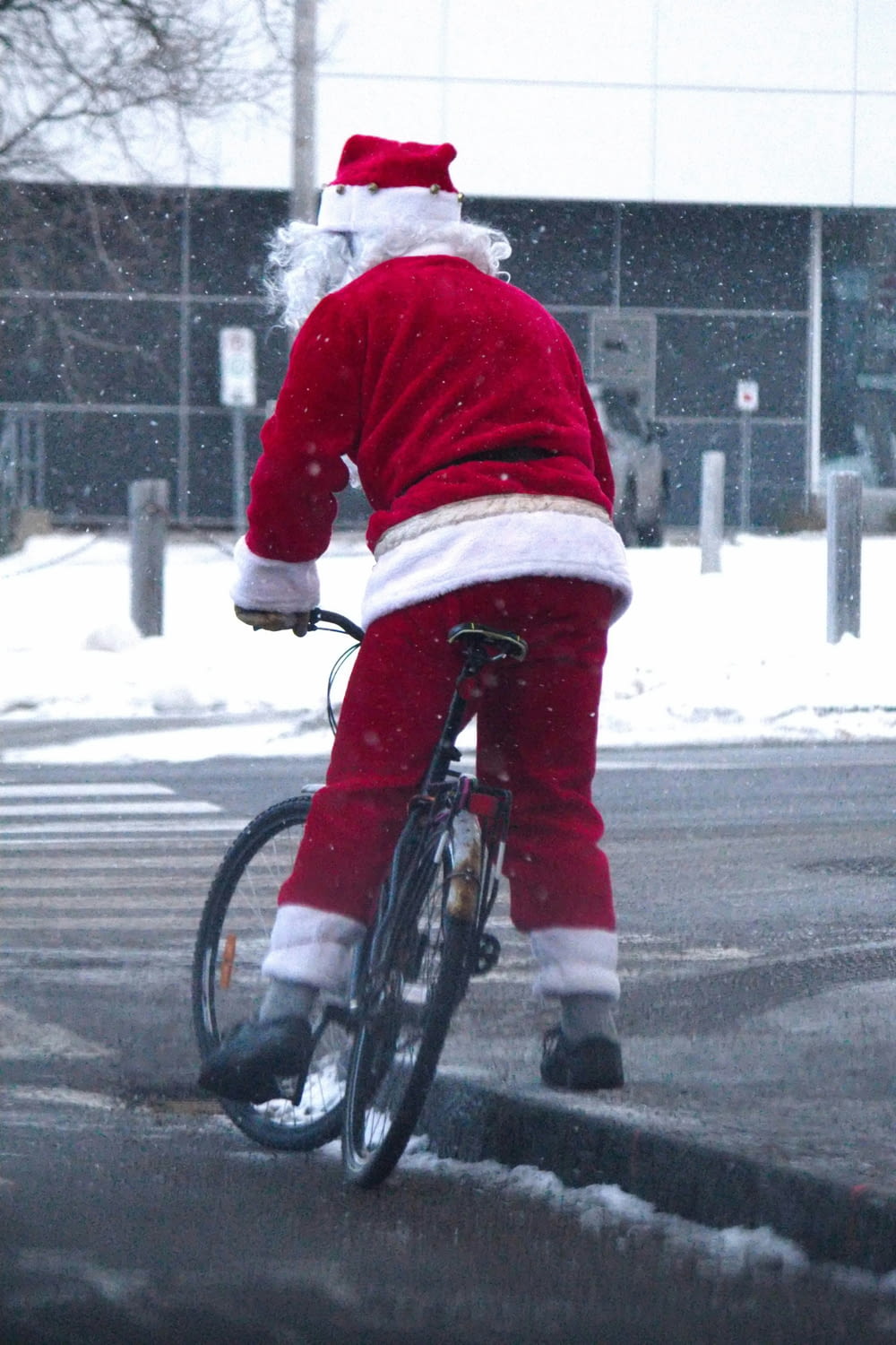 a man dressed as santa claus riding a bike