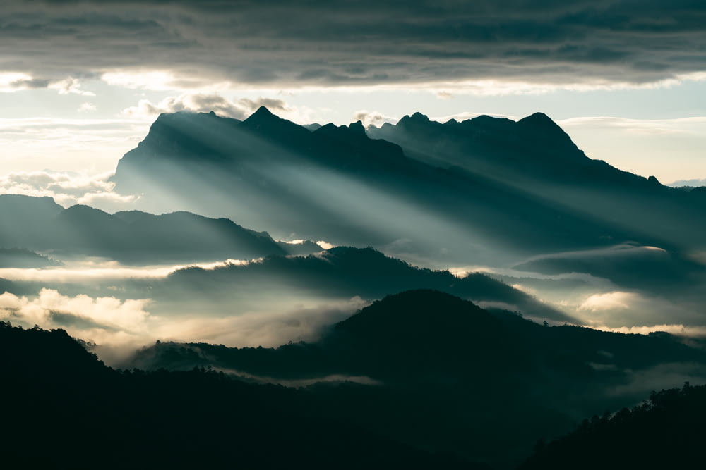 the sun shines through the clouds in the mountains