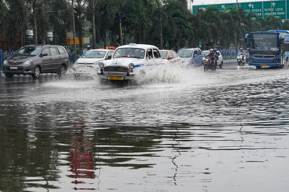 a group of cars driving down a flooded street