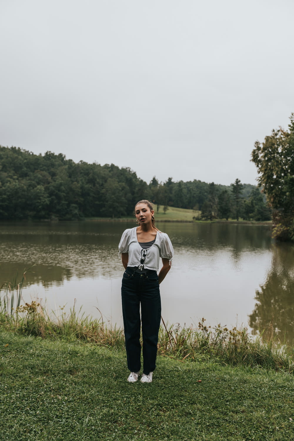 a woman standing in front of a lake