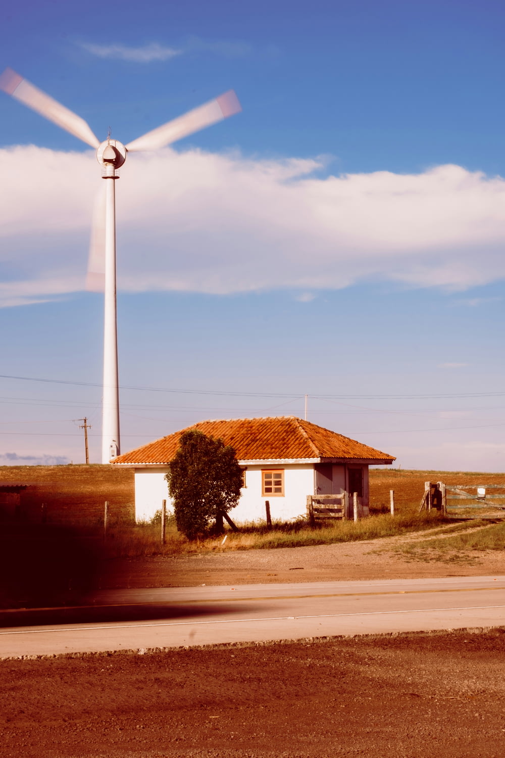 a windmill in the distance with a house in the foreground