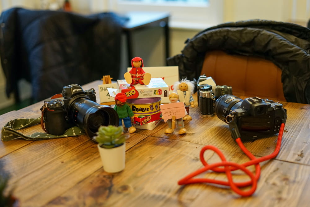 a wooden table topped with toys and a camera
