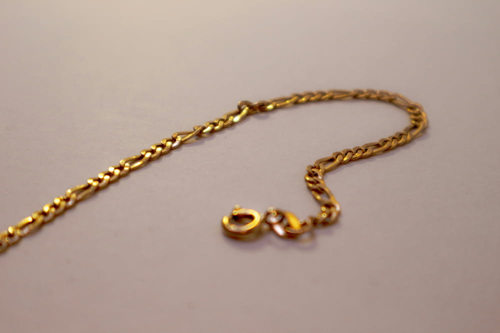 a close up of a gold chain on a table