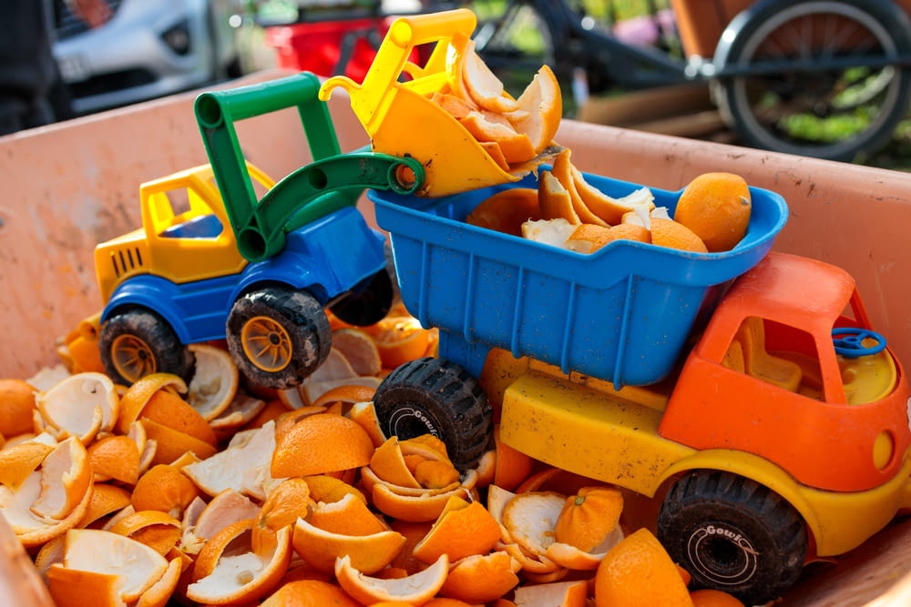 a toy truck filled with orange peels in a bin