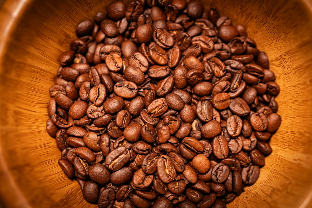 a wooden bowl filled with lots of coffee beans
