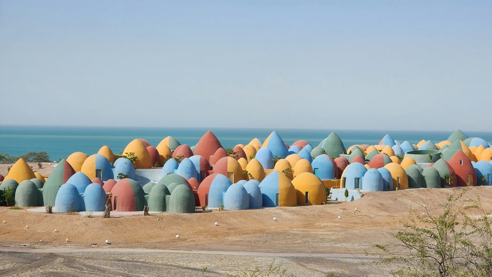 a group of colorfully painted beach huts on a beach