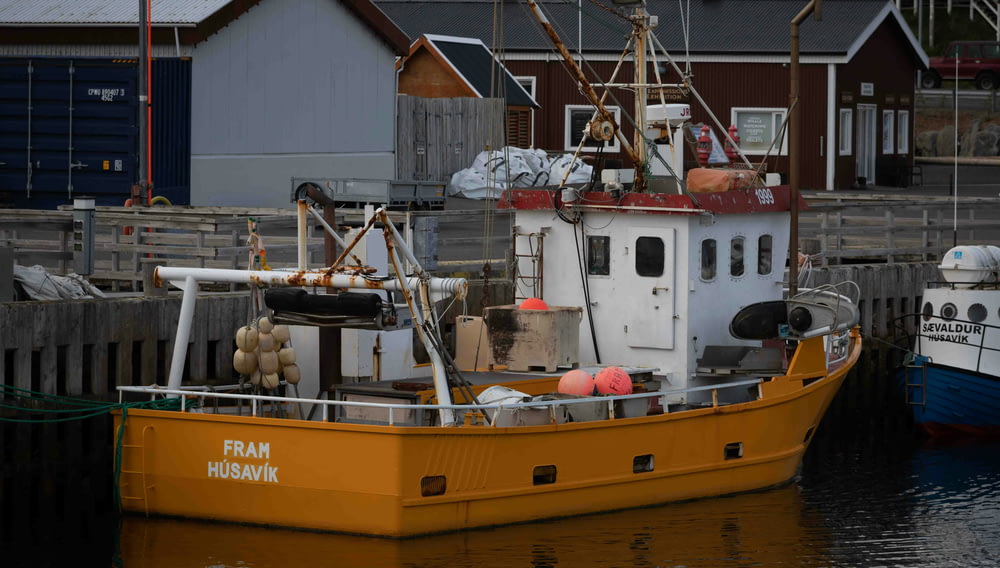 a yellow boat is docked at a dock