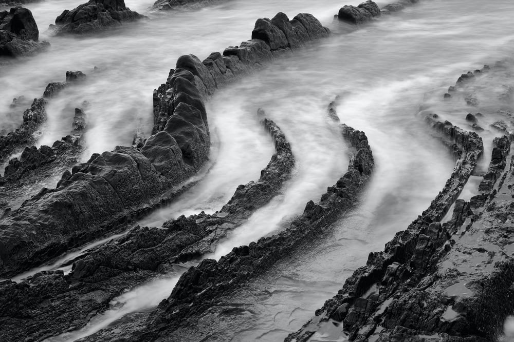 una foto in bianco e nero di rocce e acqua