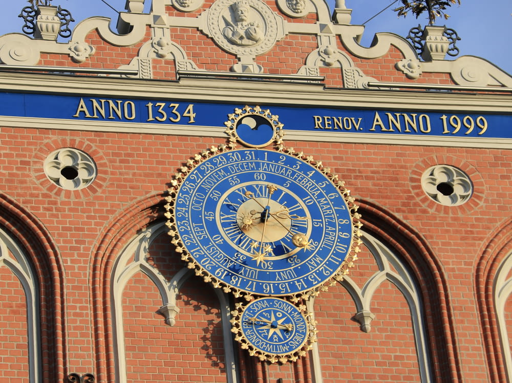 eine große blau-goldene Uhr an der Seite eines Gebäudes