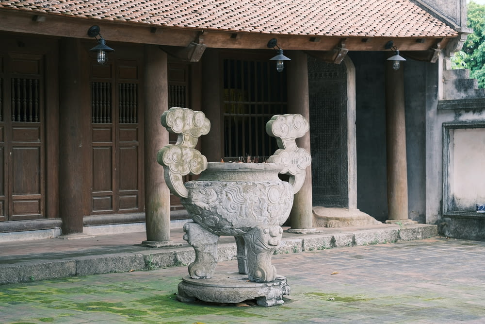 a large stone vase sitting in front of a building