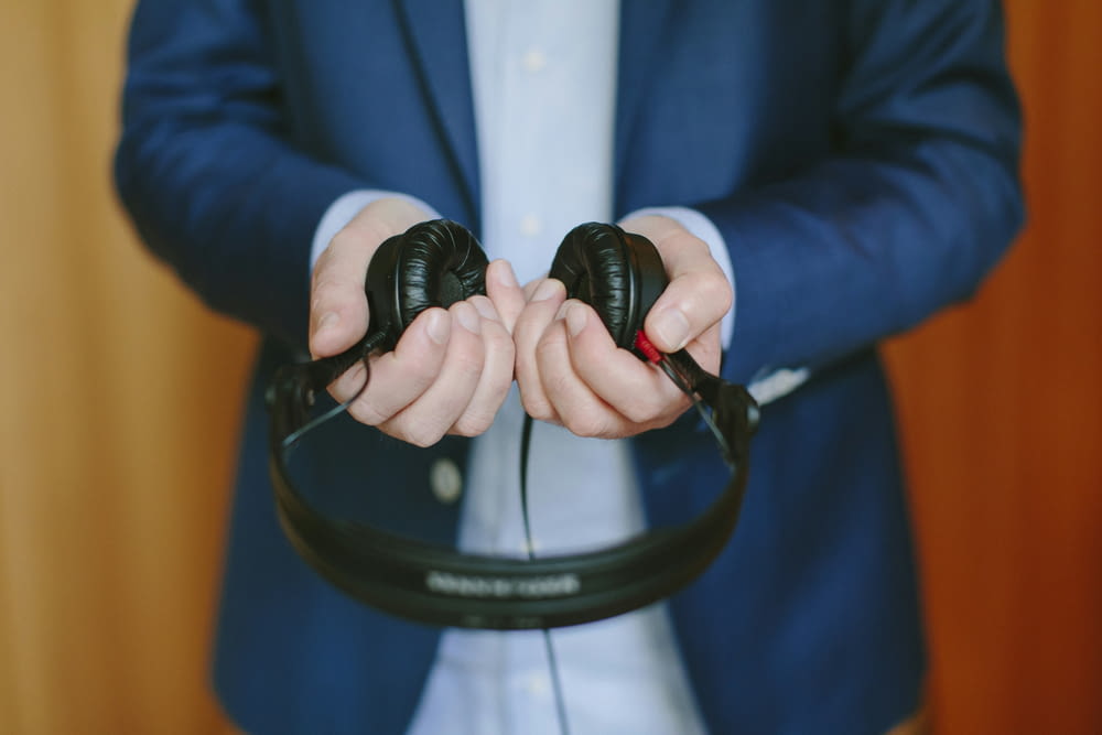a man in a suit holding a pair of headphones