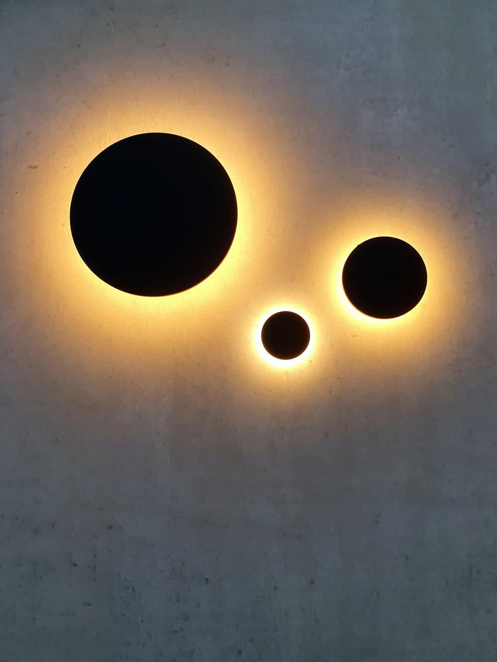 a couple of black circles sitting on top of a cement wall
