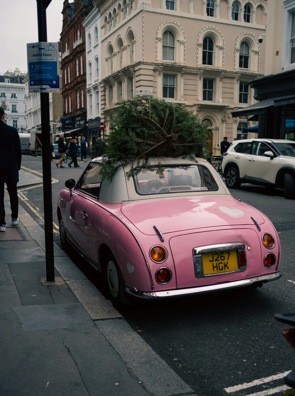 a pink car with a christmas tree on top of it