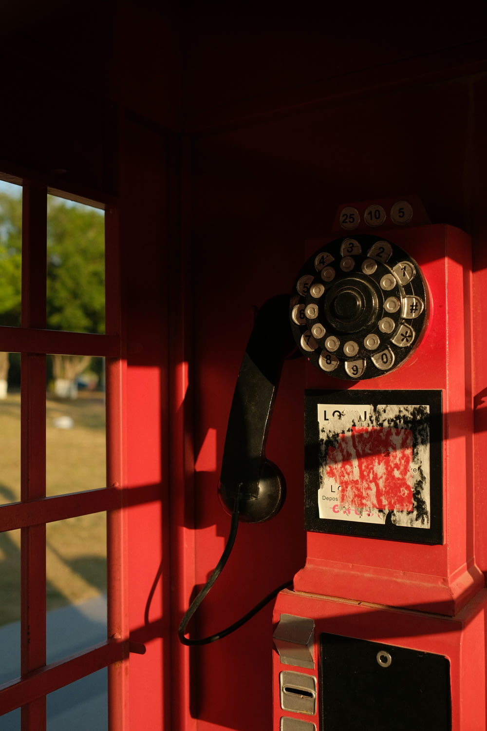 a red phone booth with a phone on top of it