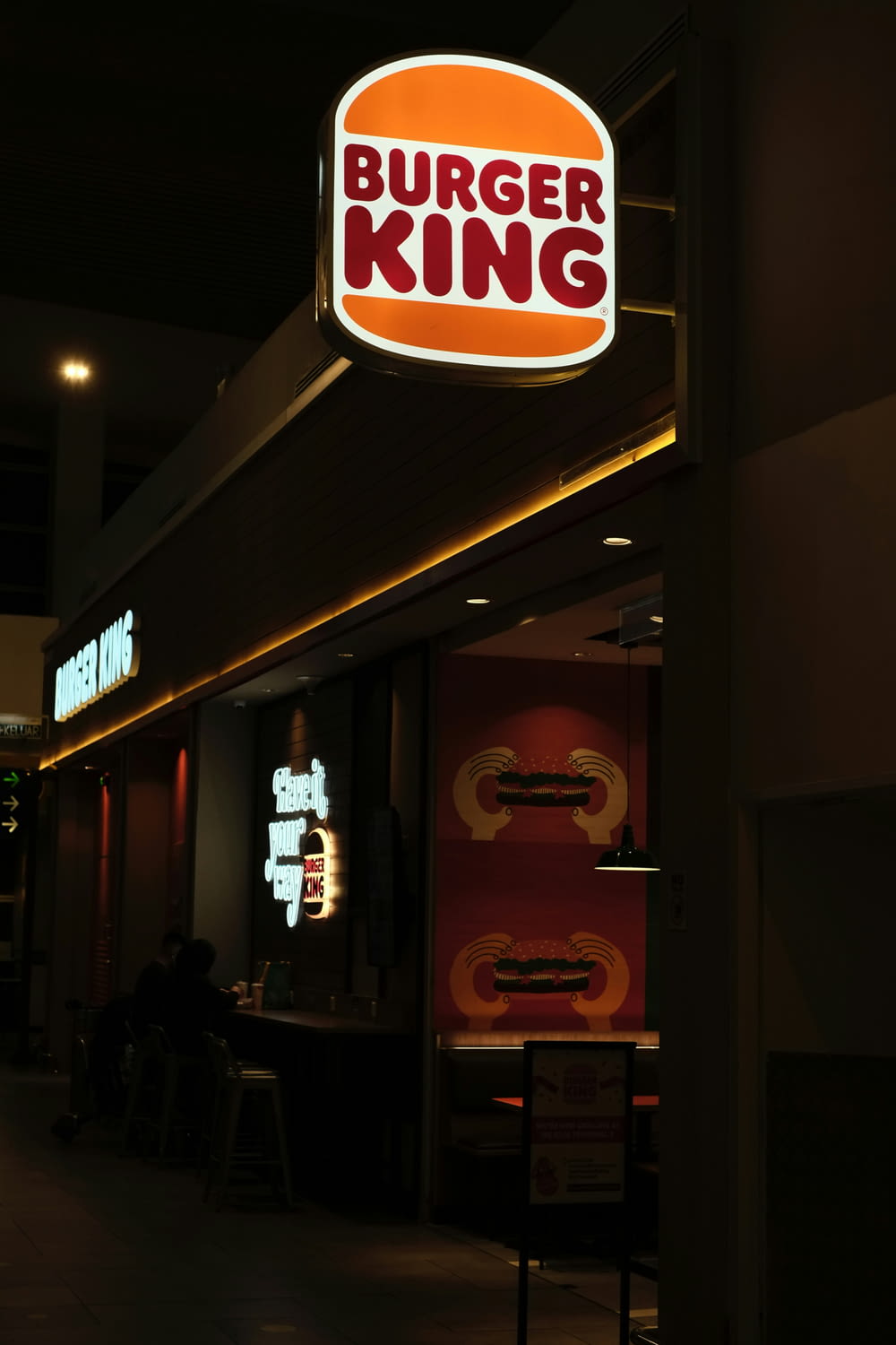a burger king sign is lit up at night