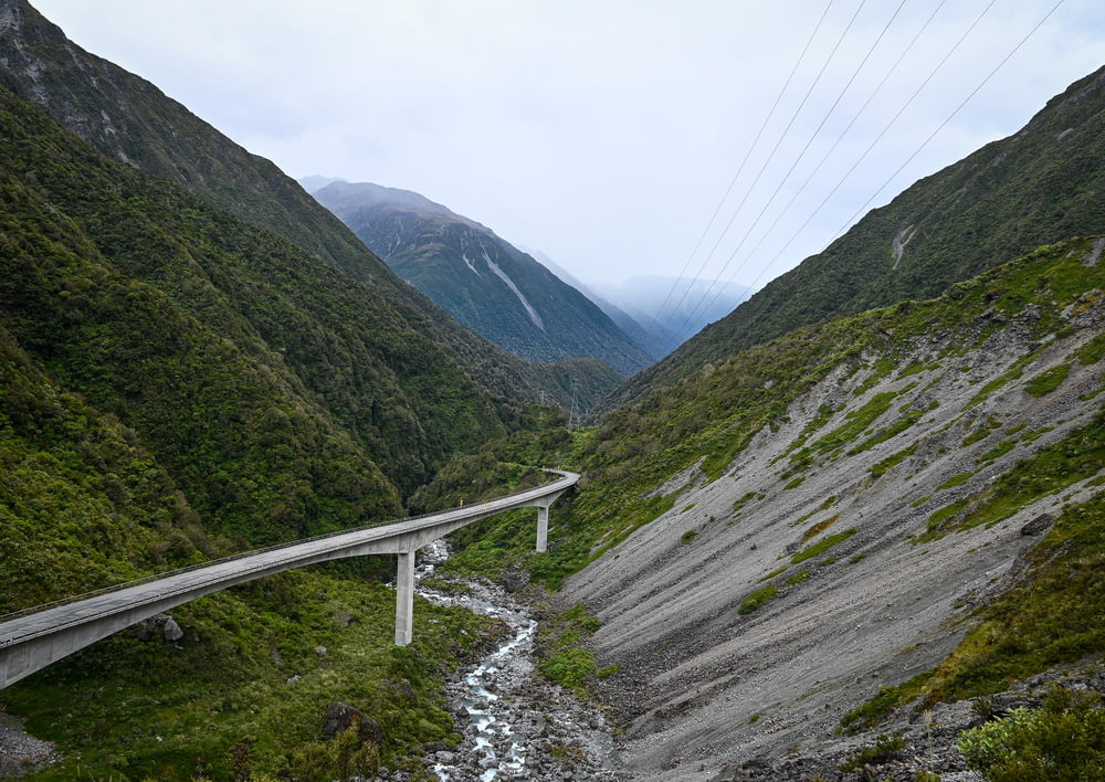 a road going through a valley with mountains in the background