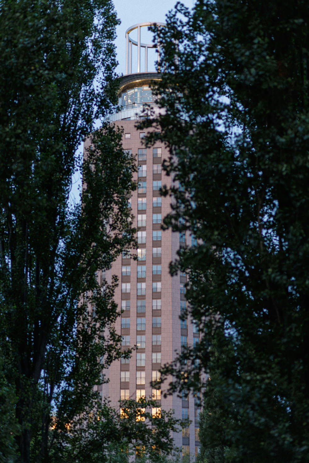 a tall building surrounded by trees at dusk