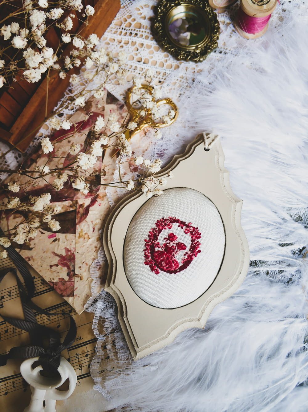 a white table topped with a cross stitch wreath
