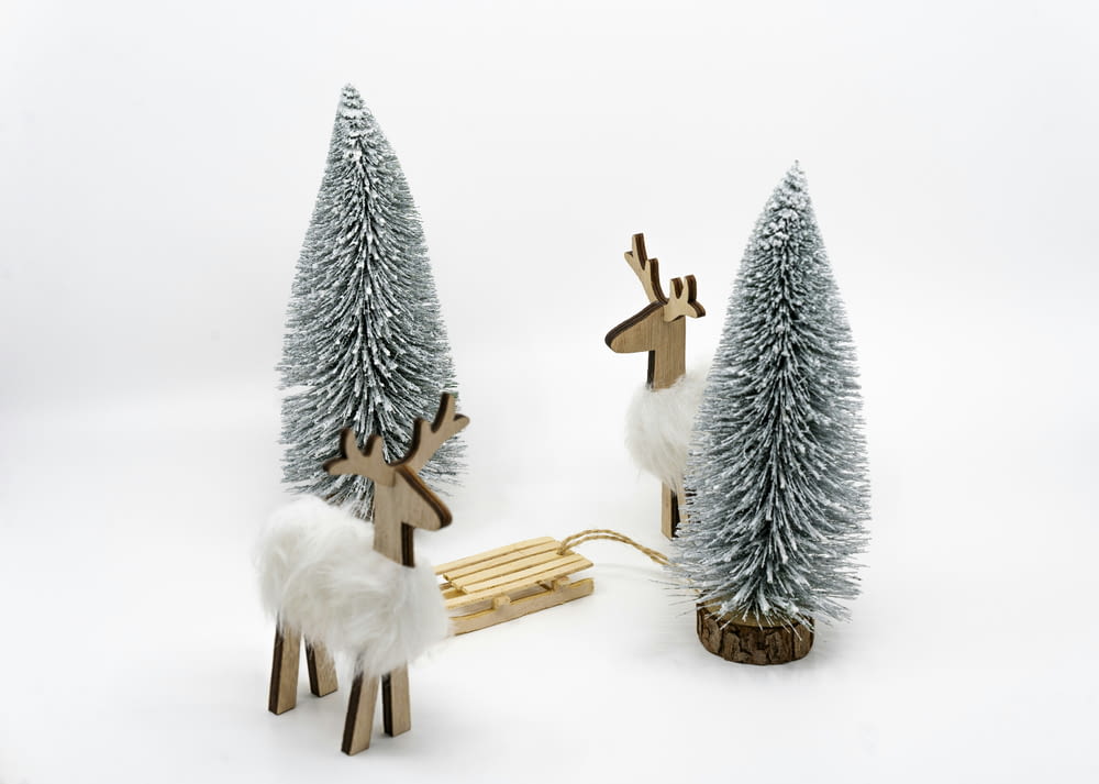 a couple of wooden reindeer standing next to a sleigh