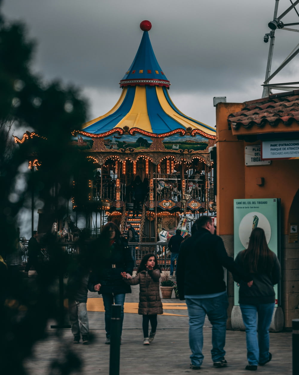 a group of people walking around a merry go round