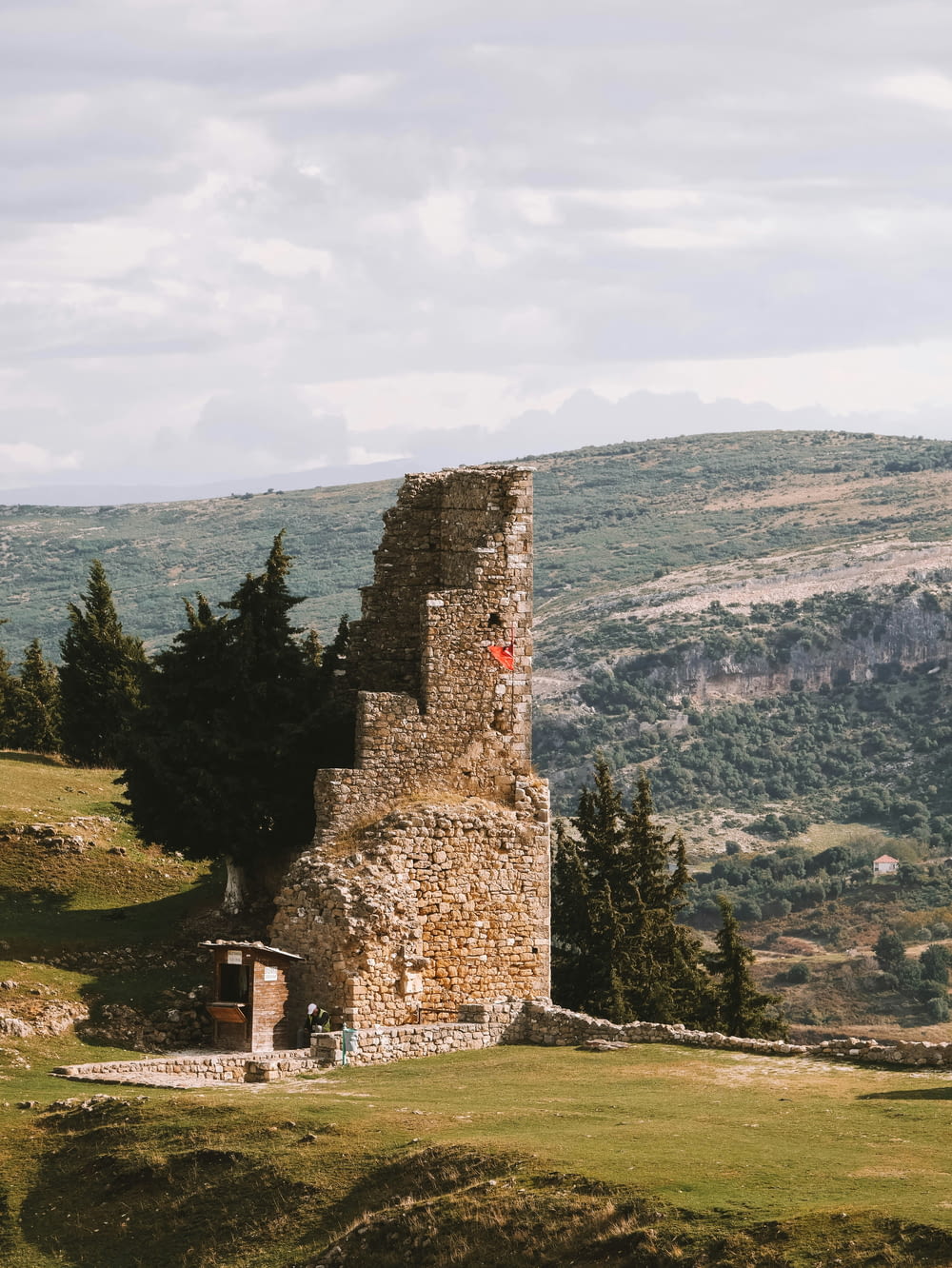 a stone tower sitting on top of a lush green hillside
