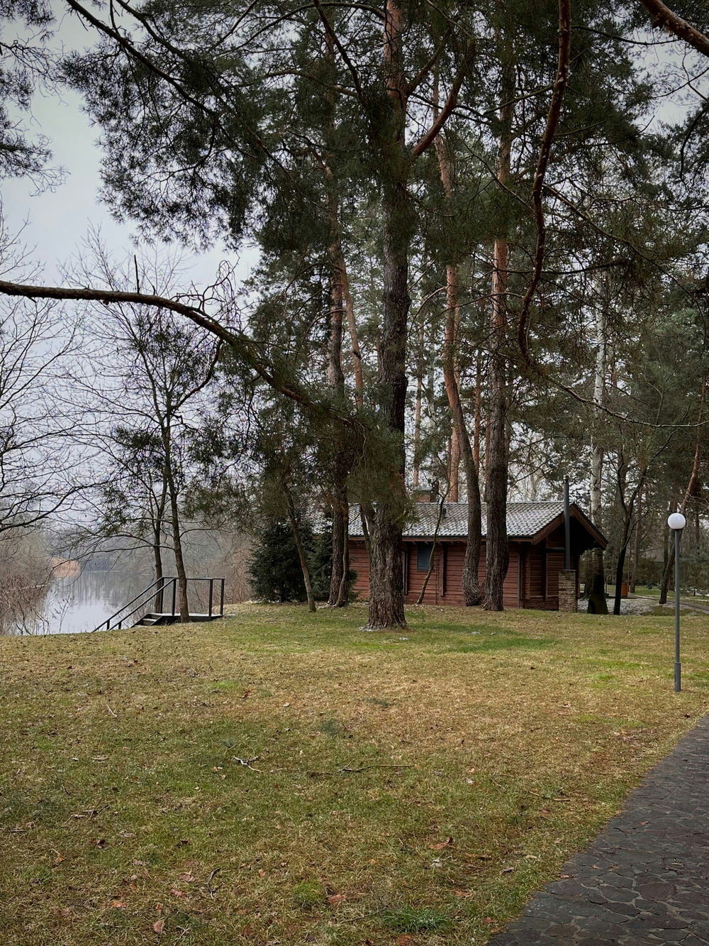a house sitting next to a lake surrounded by trees