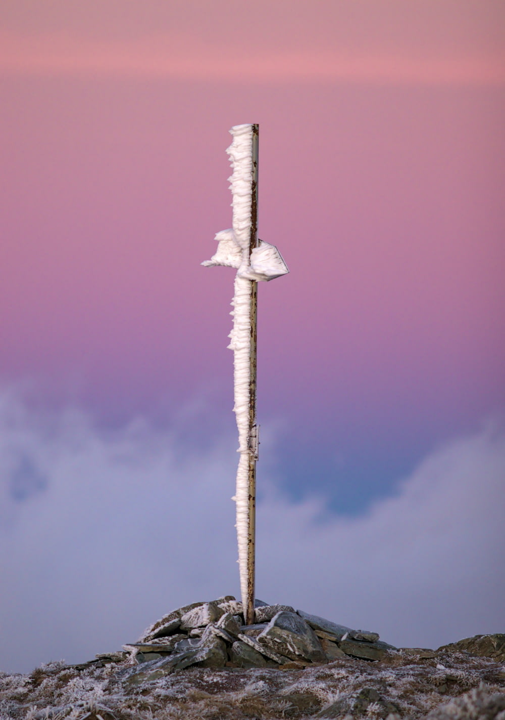 a tall wooden pole sitting on top of a mountain