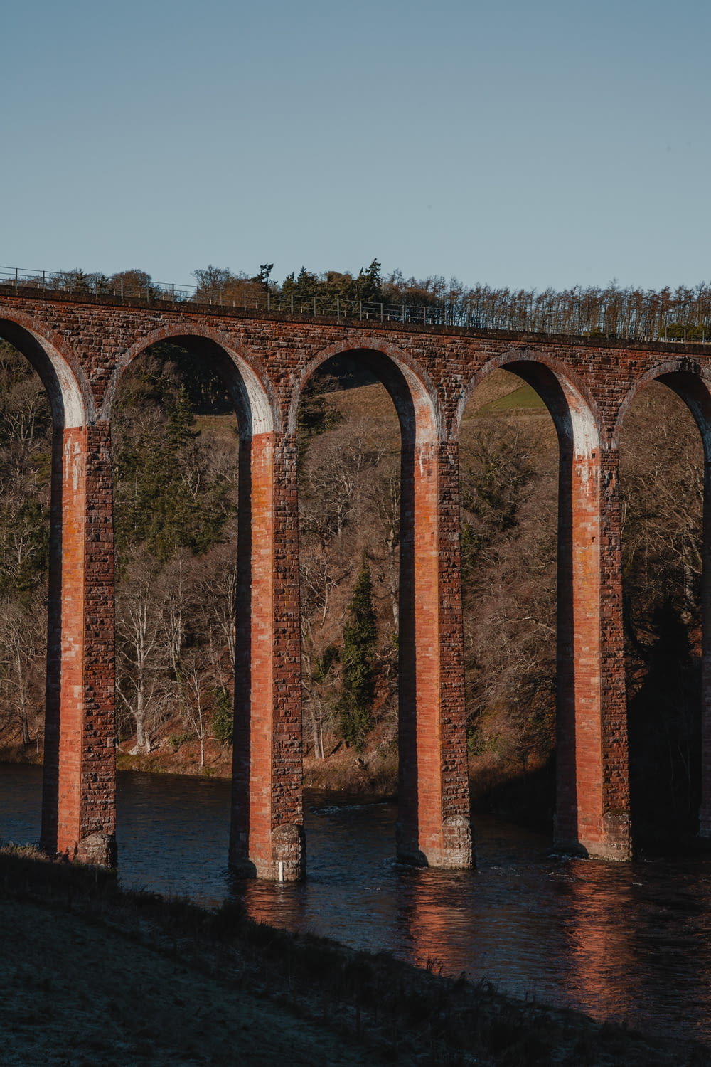 an old brick train bridge over a river